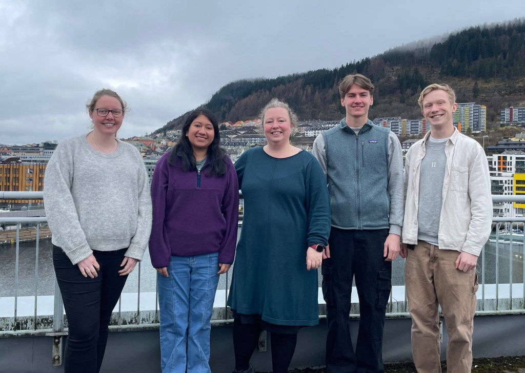 An image of five people standing outside.